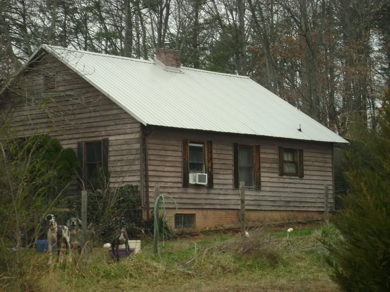 White metal roof on an old wood sided farmhouse, from a Metal Roof Installation job in Bayview